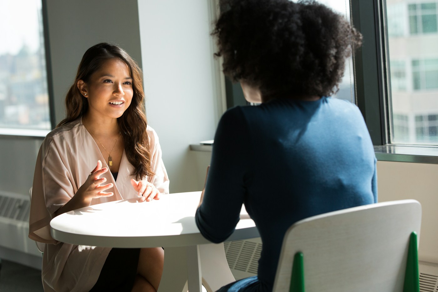 Two professionals sharing a thoughtful conversation in a bright workspace